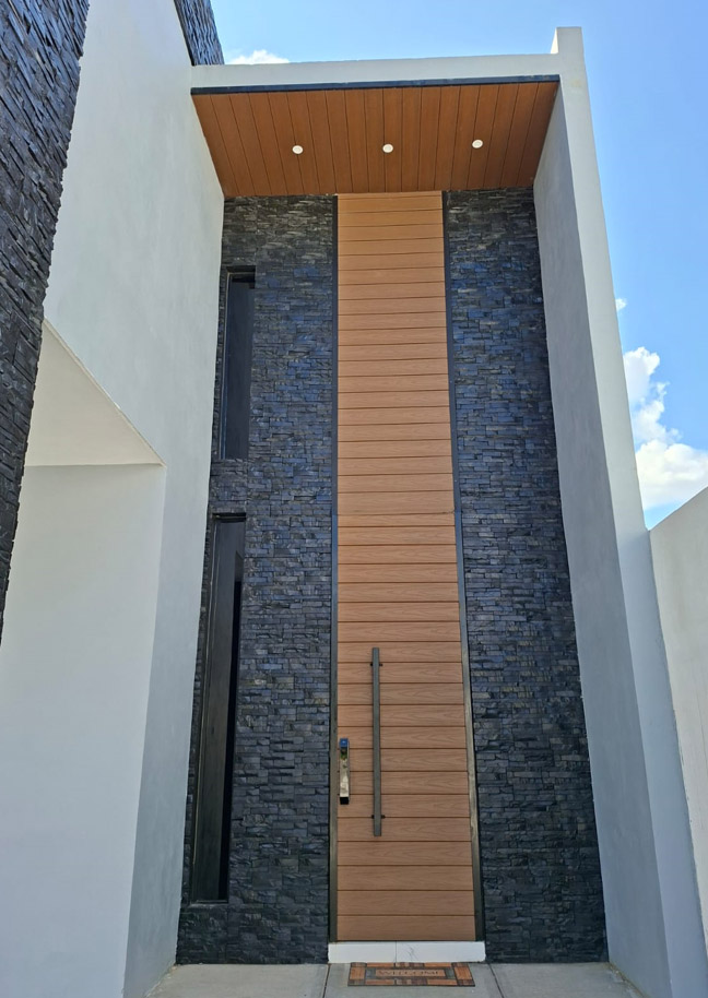 Wood finish steel pivot door vertical slat Texas modern home